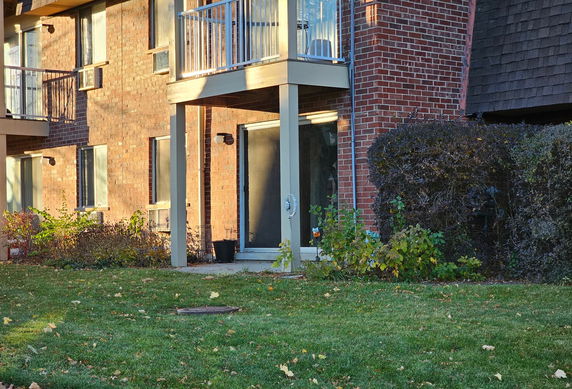 Front view of a brick building with balconies and glass doors.