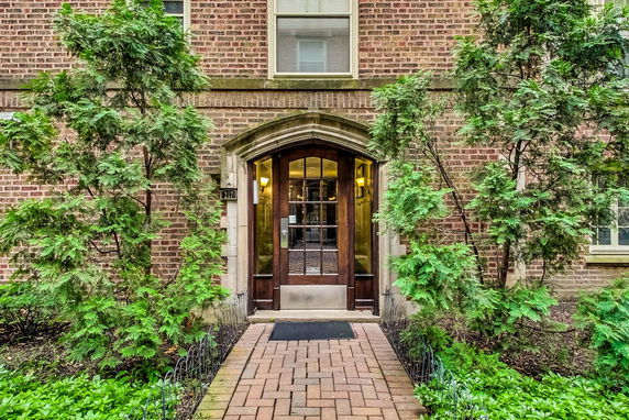 Front view of a brick building entrance with wooden doors.