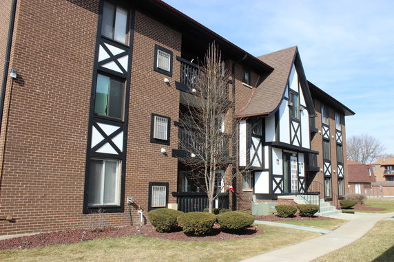 Front view of a multi-story building with brick facade and decorative elements.