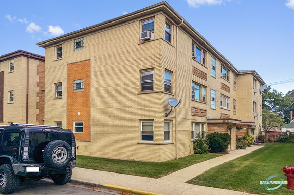 Front view of a three-story apartment building with brick exterior.