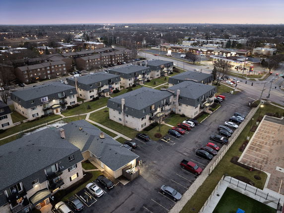 Panoramic view of residential buildings and parking areas in a suburban neighborhood.