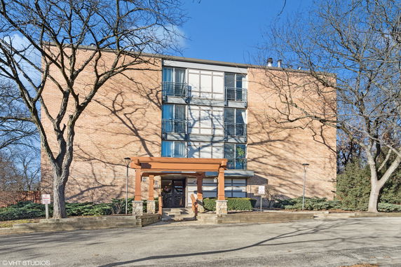 Front view of a multi-story brick building with a small entrance canopy.