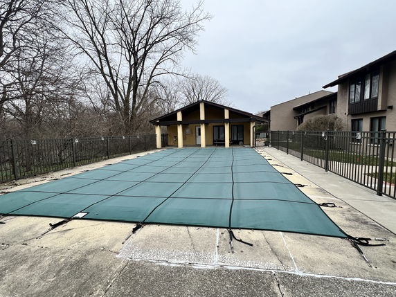 Covered outdoor swimming pool and adjacent building.