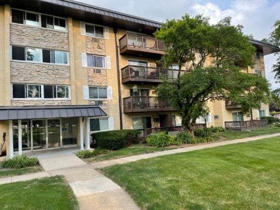 Front view of a multi-story residential building with balconies.