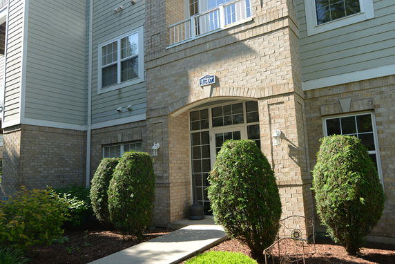 Front view of a multi-story building with brick and siding facade.