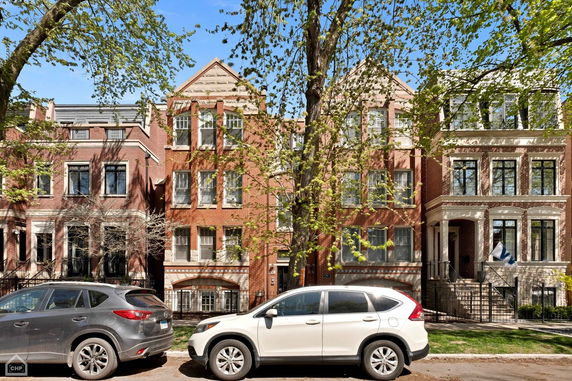 Front view of three-story brick houses in a residential area.