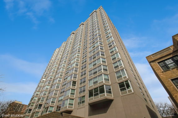Front view of a tall residential building with multiple windows.