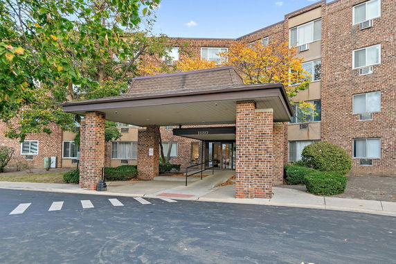 Front view of a brick multi-story building with a covered entrance.