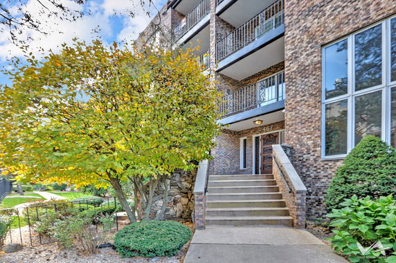 Front view of a multi-story building with brick facade and balconies.