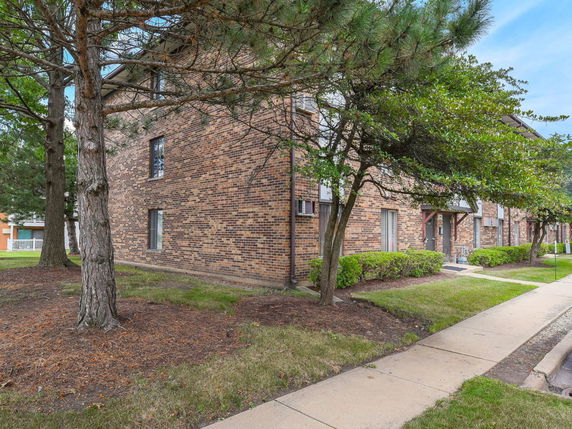 Front view of a brick multi-story apartment building.