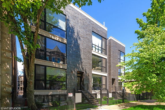 Front view of a modern multi-story building with large glass windows and brick exterior.