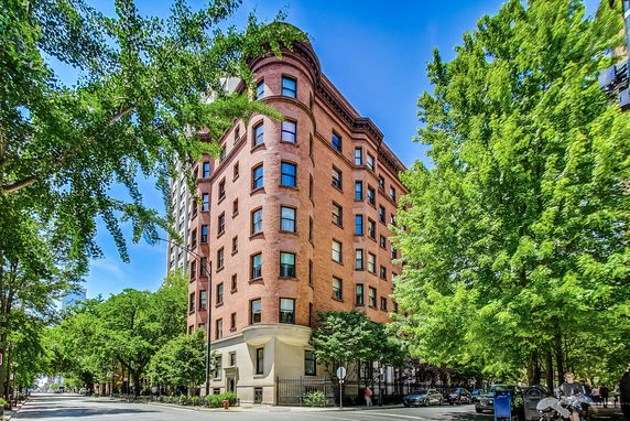 Front view of a multi-story brick building on a street corner.