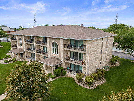 Front view of a multi-story residential building with multiple balconies.