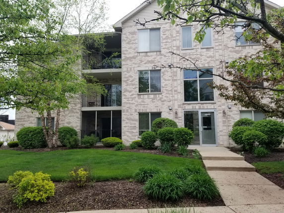 Front view of a multi-story residential building with brick exterior.
