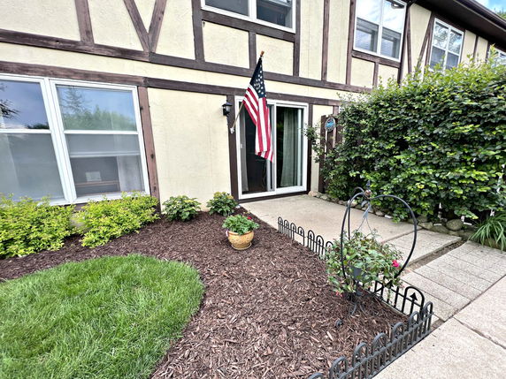 Front view of a two-story house with wooden beams and a flag hanging beside the entrance.