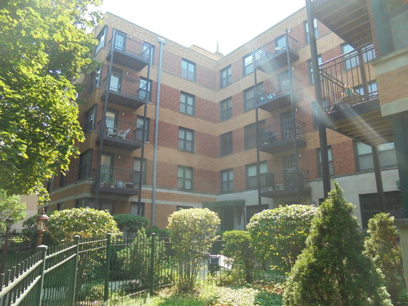 Front view of a multi-story apartment building with balconies.