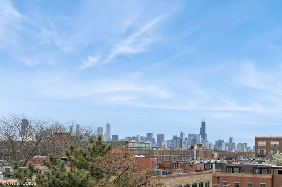 Wide angle view of a city skyline with various buildings and a clear blue sky.