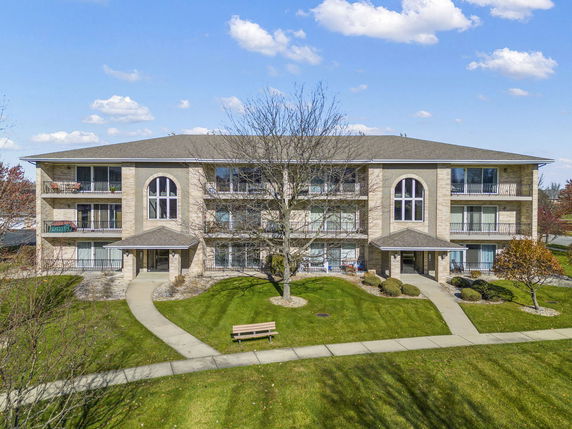 Front view of a three-story apartment building with balconies.