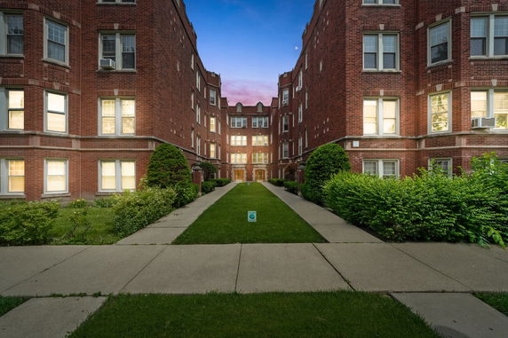 Front view of a brick apartment building complex with multiple stories.