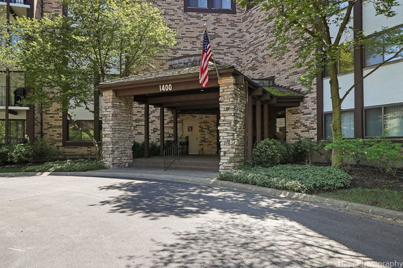 Front view of a building with brick facade and stone columns at the entrance.