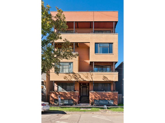 Front view of a three-story building with a brick facade.