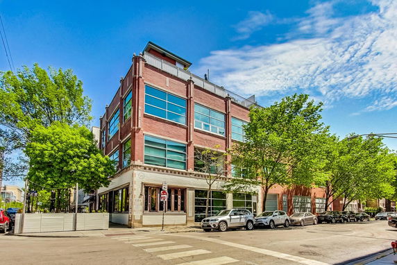 Front view of a multi-story building with modern windows and brick exterior.