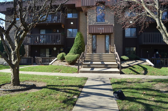 Front view of a multi-story building with balconies and a central entrance.