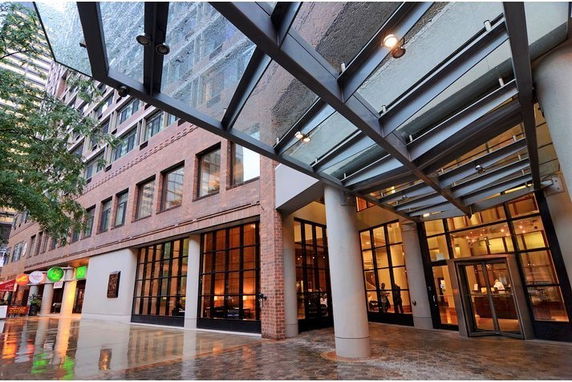 Front view of a multi-story building with large glass windows and a glass canopy.