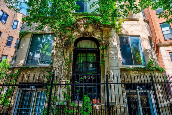 Front view of a multi-story building with ornate details and ivy-covered facade.