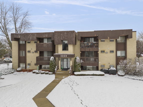 Front view of a multi-story apartment building with balconies.