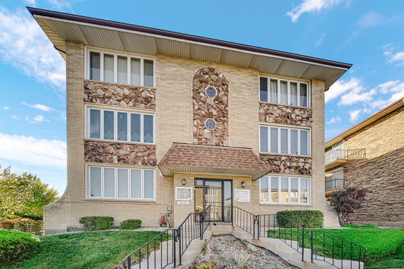 Front view of a three-story residential building with stone accents.