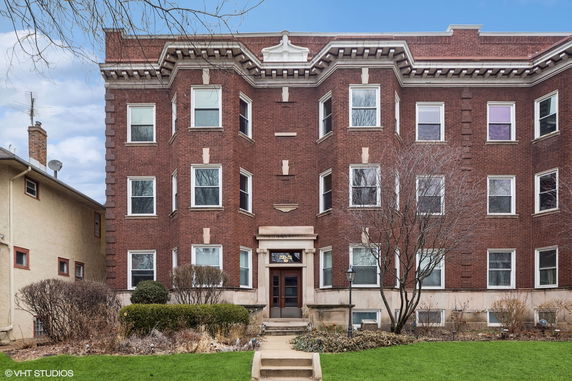 Front view of a three-story brick building with multiple windows and a central entrance.