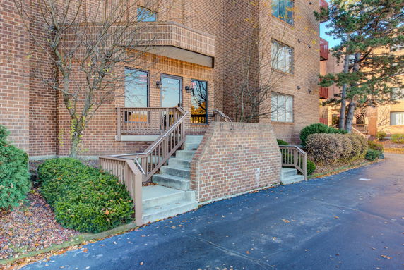 Front view of a brick apartment building with entrance steps.