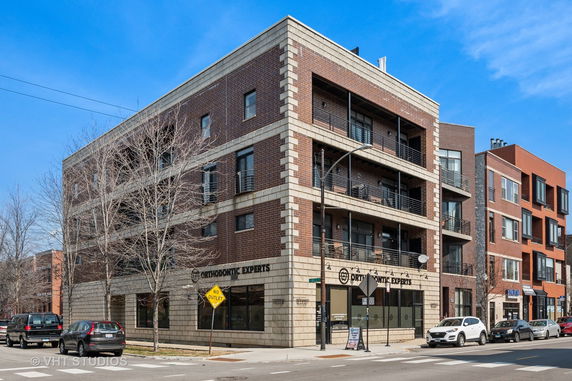 Front view of a multi-story commercial and residential building with balconies.
