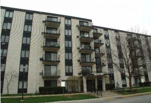 Front view of a multi-story apartment building with balconies.