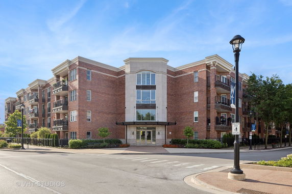 Front view of a multi-story brick building with balconies.