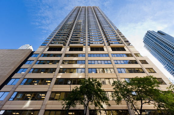 Front view of a modern high-rise building with numerous glass windows and a symmetrical design.