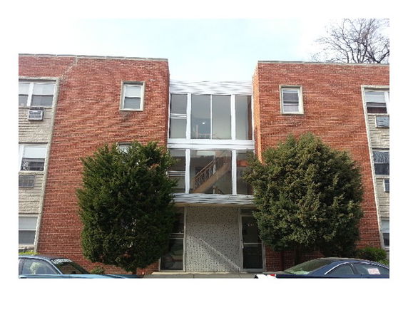 Front view of a mid-sized brick apartment building with multiple windows.