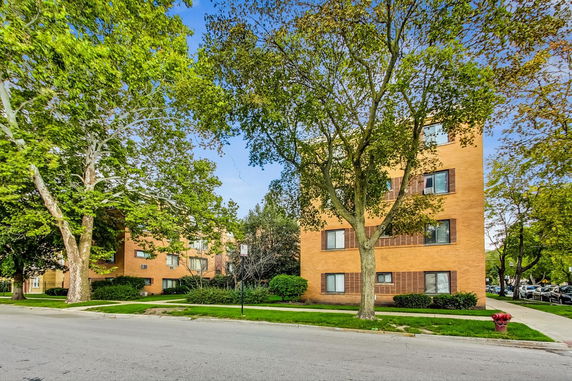 Front view of a multi-story apartment building with a brick exterior.