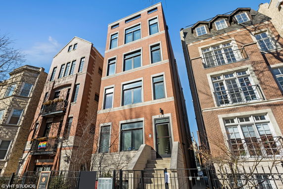 Front view of a multi-story brick building with large windows.
