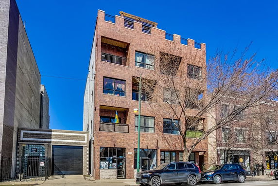 Front view of a multi-story brick building with a crenellated roofline.