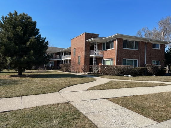 Front view of a brick multi-story building with surrounding pathways.