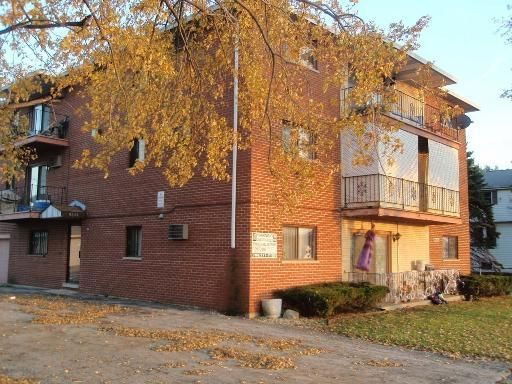 Front view of a multi-story brick building with balconies.