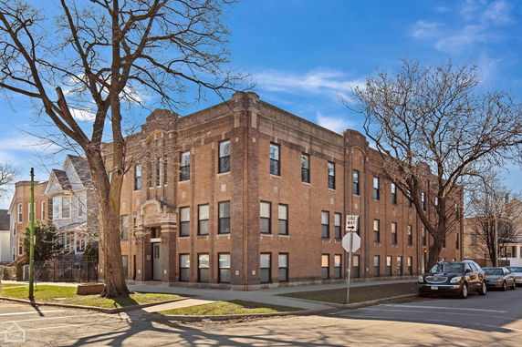 Front view of a two-story brick building on a street corner.