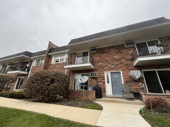Front view of a two-story brick building with balconies.