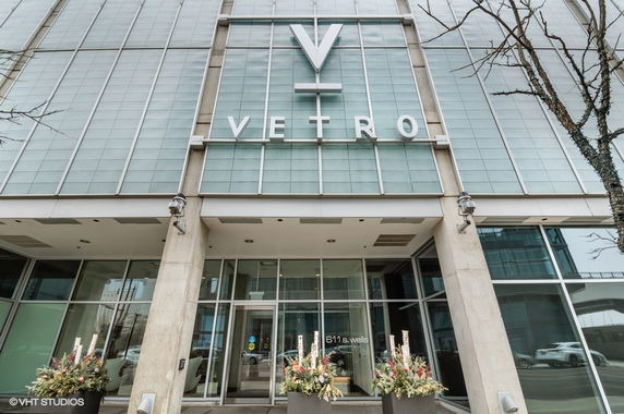 Front view of a modern building with large glass panels and prominent signage.