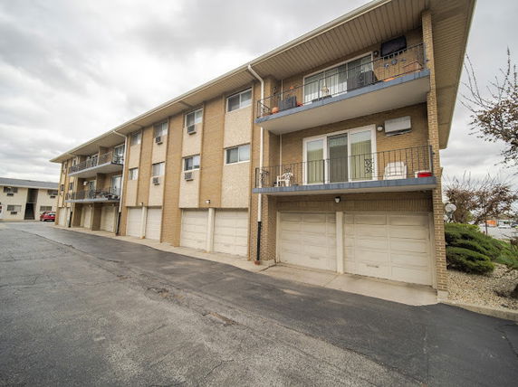 Front view of a three-story residential building with garages.