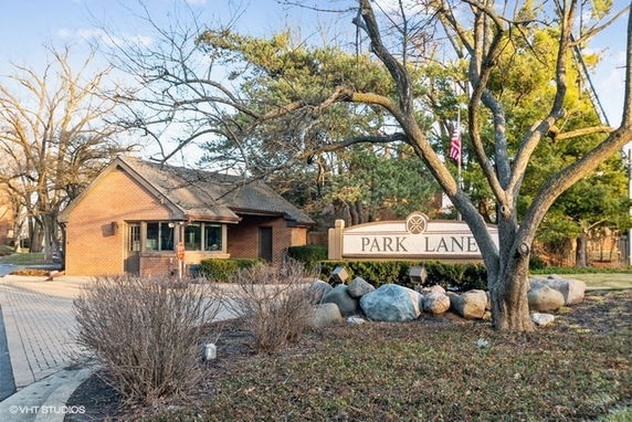 Front view of a single-story brick building next to sign reading 'Park Lane'.