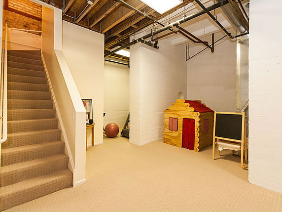 Indoor area with a playhouse and exposed ceiling beams.