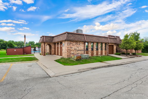 Front view of a single-story brick building with a flat roof and multiple arched doorways.